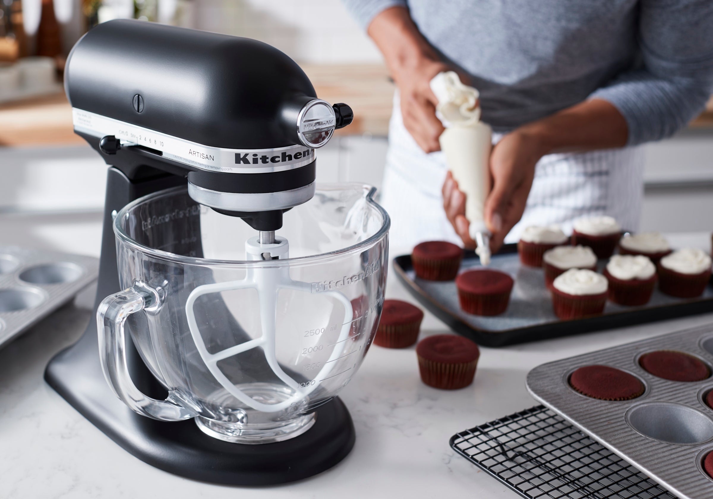 Black KitchenAid Artisan KSM150 stand mixer preparing cupcakes